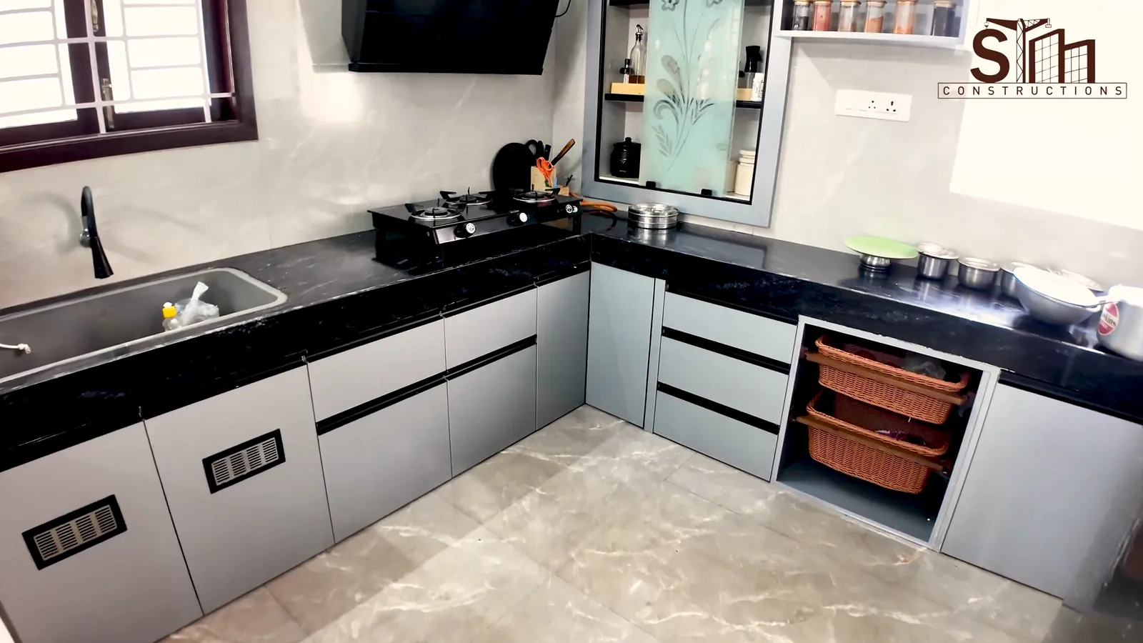 L-shaped kitchen with grey cabinets in the Kulur, Erode house